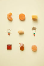 Load image into Gallery viewer, Jewelry and food composition with coral carrot earring and gold necklace