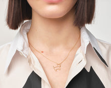 Load image into Gallery viewer, Model wearing gold chain necklace with small dog shaped pendant