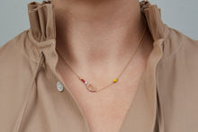 Load image into Gallery viewer, Gold chain necklace with gold tennis racquet and ball shaped pendants in pink and yellow enamel worn by model
