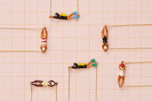 Load image into Gallery viewer, Jewelry composition with gold necklaces with swimmer shaped pendants