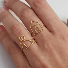 Load image into Gallery viewer, Woman wearing gold rings shaped like a little rabbit and a little house with ruby stone
