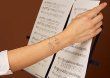 Load image into Gallery viewer, White gold chain bracelets with house and dinosaur shaped pendants on model's arm