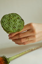 Load image into Gallery viewer, Hand holding a green flower and wearing a turtle shaped gold ring