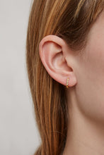 Load image into Gallery viewer, Woman wearing a gold small hoop earring with a zig-zag texture