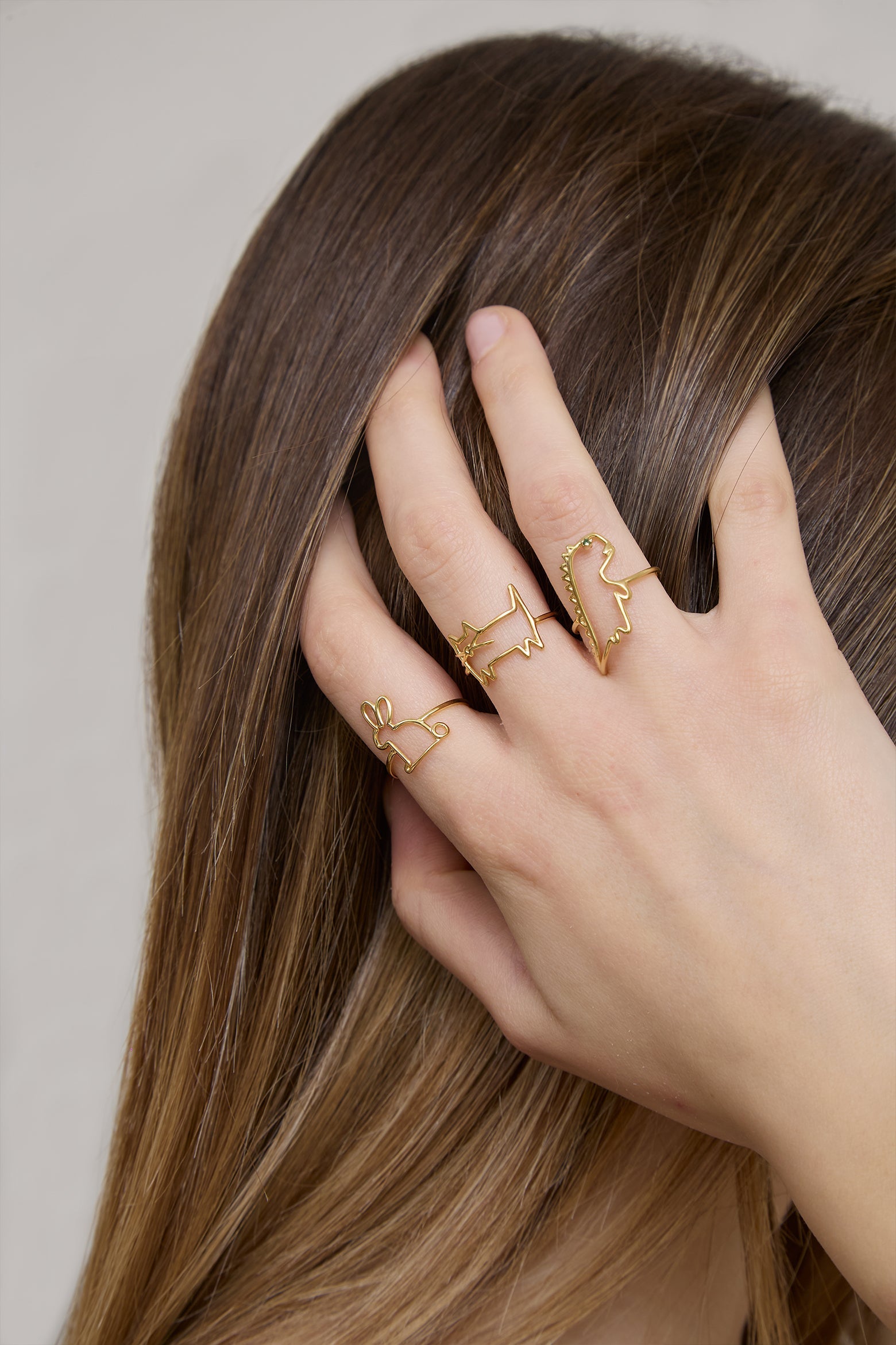 Dinosaur shaped gold ring and small emerald