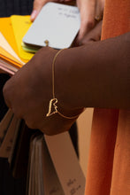 Load image into Gallery viewer, Gold chain bracelet with dinosaur shaped pendant worn by model
