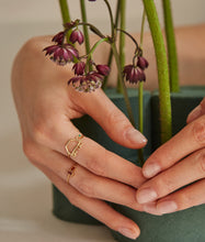 Load image into Gallery viewer, Hand with flowers wearing a gold ring shaped like a turtle with a green emerald eye
