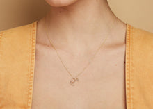 Load image into Gallery viewer, Gold chain necklace with small croissant shaped pendant worn by model
