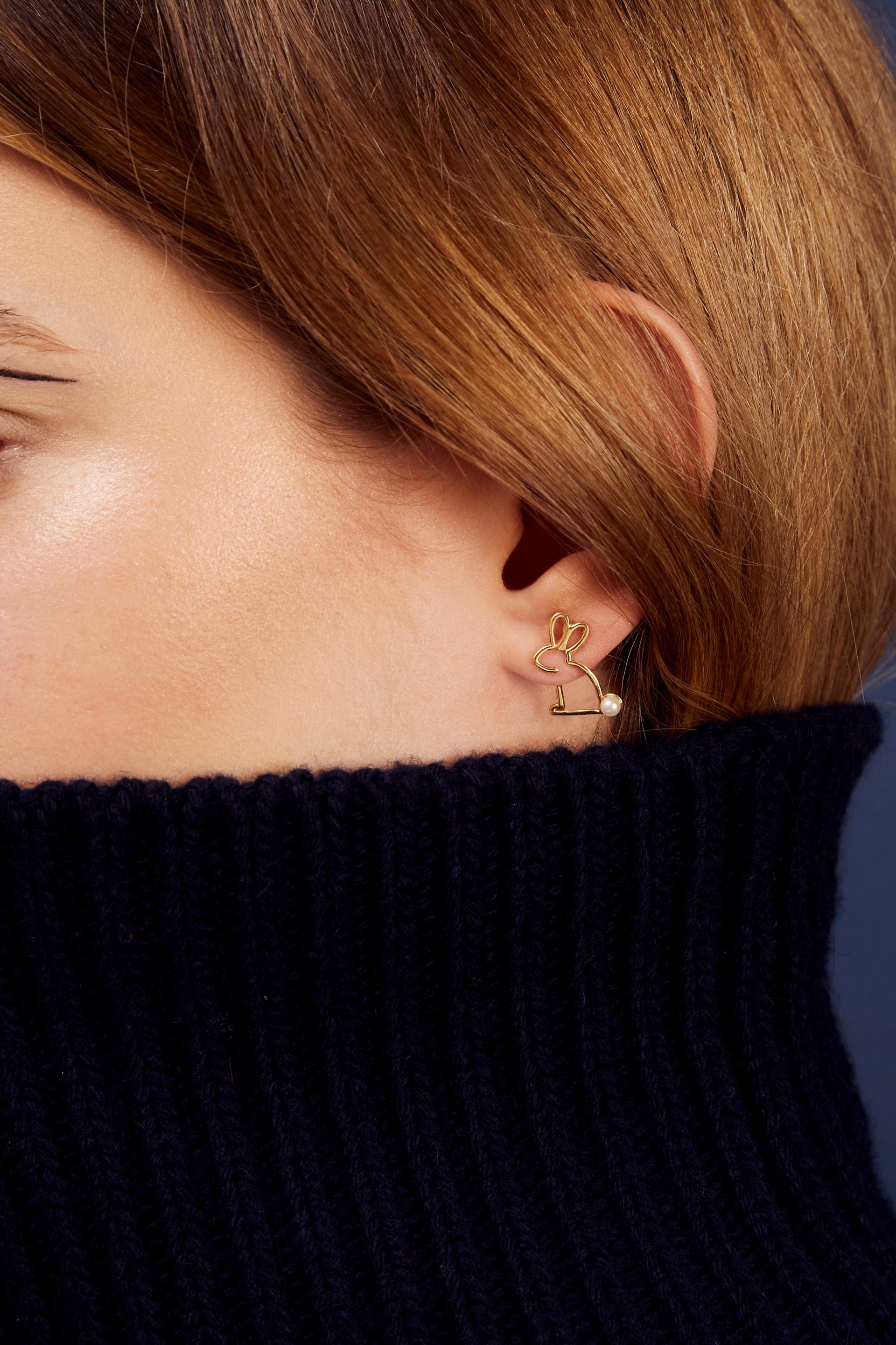 Small rabbit shaped gold earring with a pearl tail